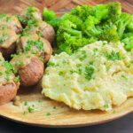 a plate of food with broccoli and mashed potatoes and tuna meat balls